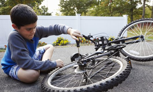 Photo of child fixing bicycle