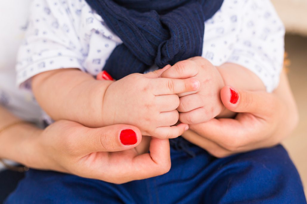 Closeup photo of mom holding baby's hands