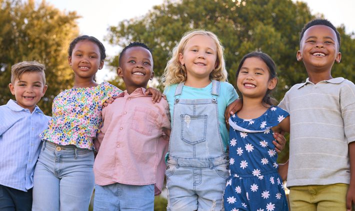 Photo of smiling children standing next to each other