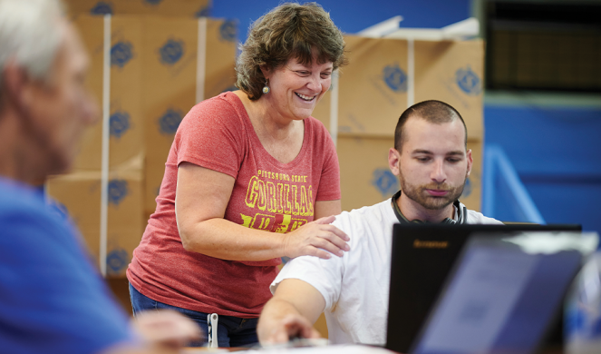 hope_wateredgardens14c Photo of volunteer helping man at computer at Watered Gardens