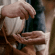 Closeup photo of biblical man dropping coins in another man's hands