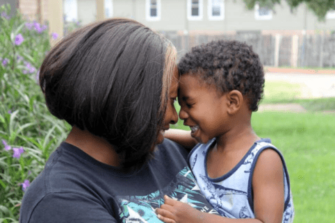 Photo of mother and son smiling together with their heads touching