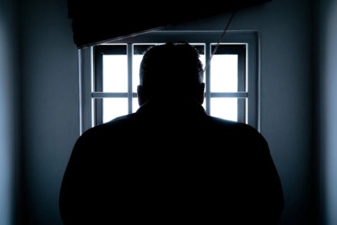 Dark silhouette of inmate in cell