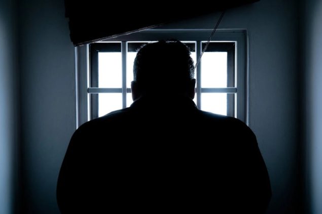 Dark silhouette of inmate in cell