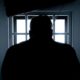 Dark silhouette of inmate in cell