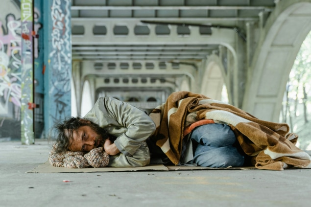 Photo of homeless man resting under bridge