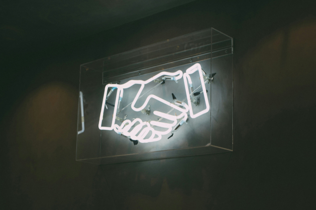 Photo of neon sign of handshake