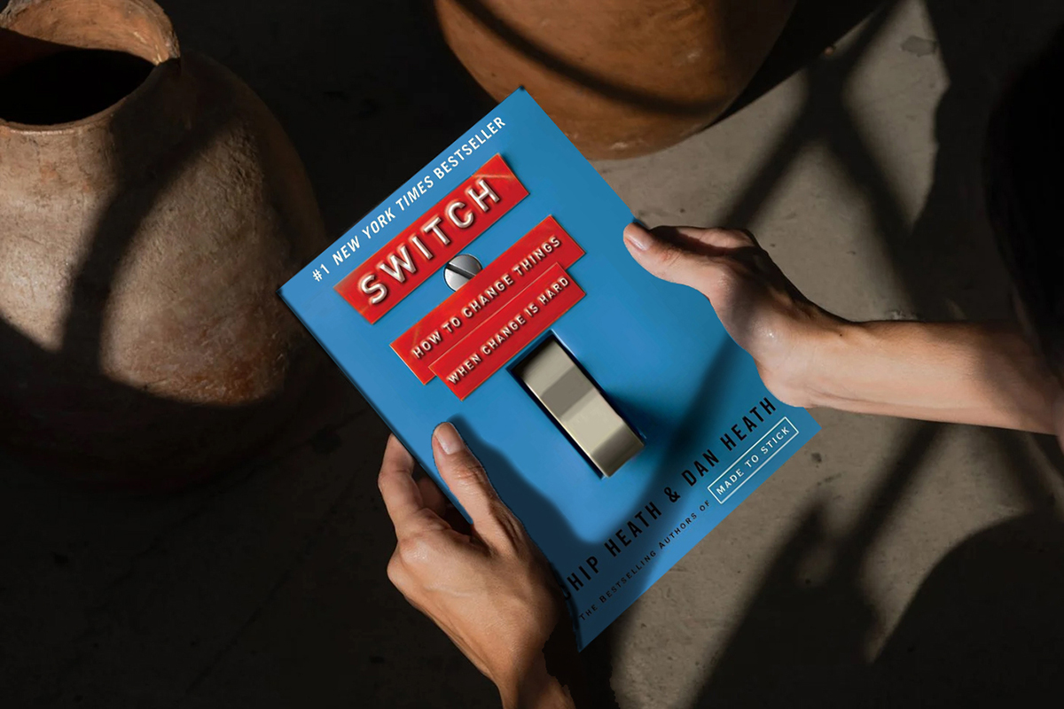 Closeup photo of the book Switch by Chip and Dan Heath behing held in a person's hands