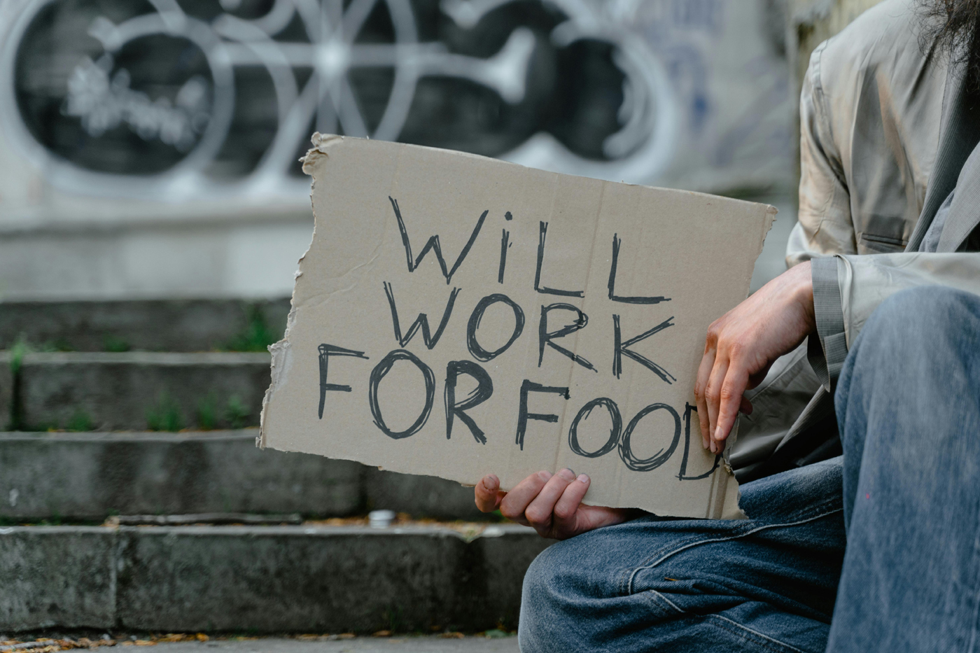Photo of homeless man holding sign