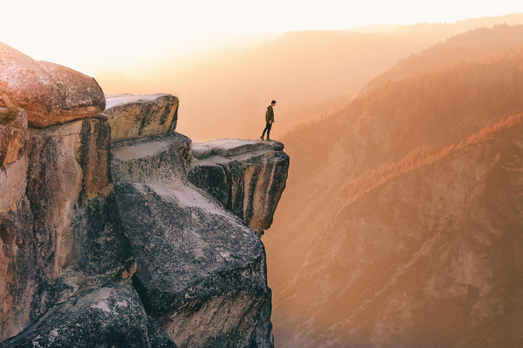Photo of man standing on edge of cliff