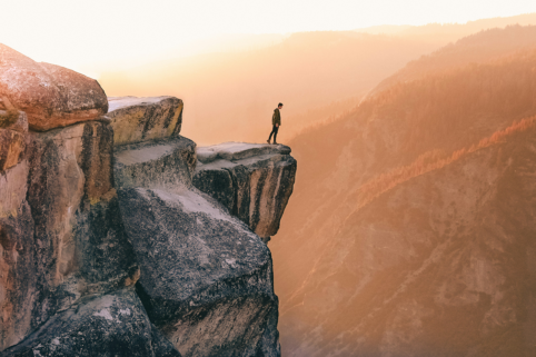Photo of man standing on edge of cliff