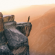 Photo of man standing on edge of cliff